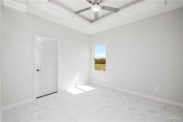 spare room featuring a raised ceiling and ceiling fan