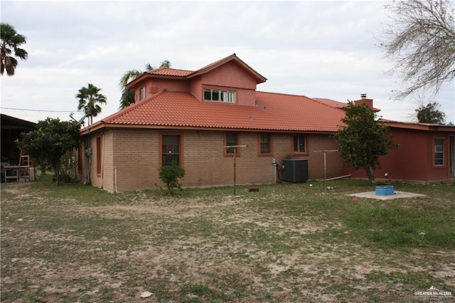 rear view of property with cooling unit and a yard