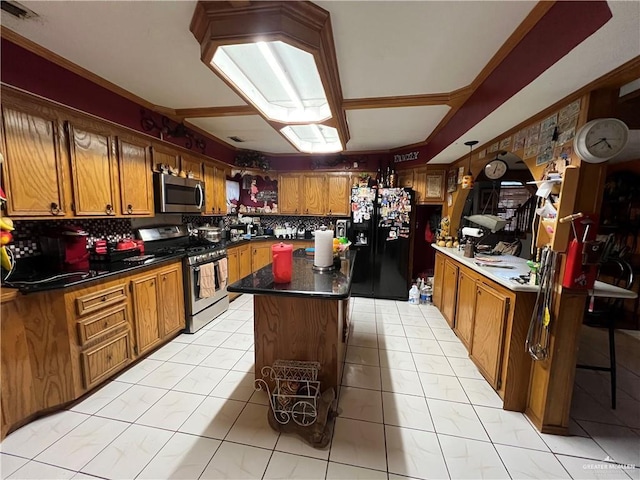 kitchen with a center island, light tile patterned floors, appliances with stainless steel finishes, and tasteful backsplash