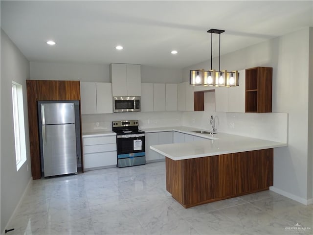 kitchen featuring kitchen peninsula, stainless steel appliances, sink, white cabinets, and hanging light fixtures