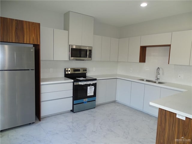 kitchen with white cabinets, appliances with stainless steel finishes, and sink