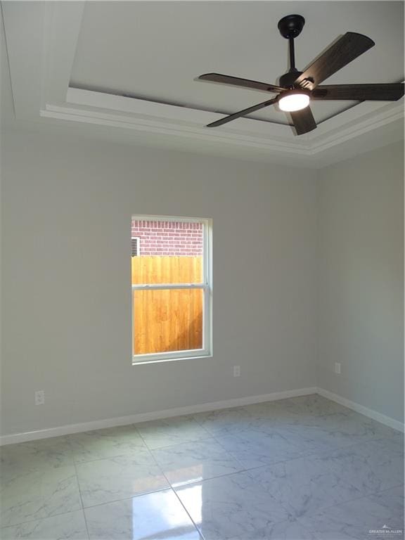 spare room featuring a tray ceiling, ceiling fan, and ornamental molding