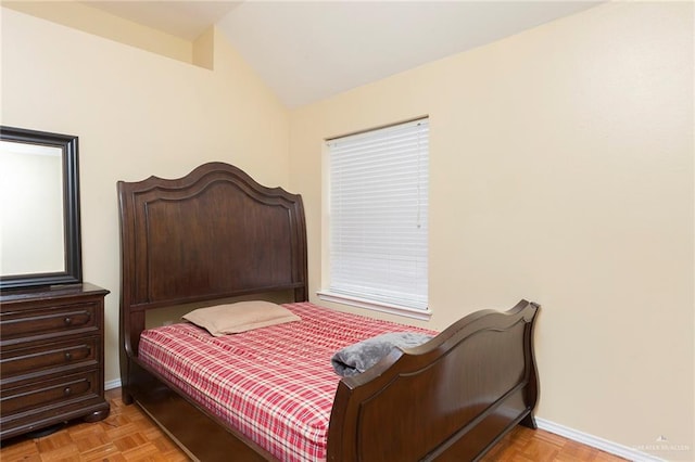 bedroom with light parquet flooring and vaulted ceiling