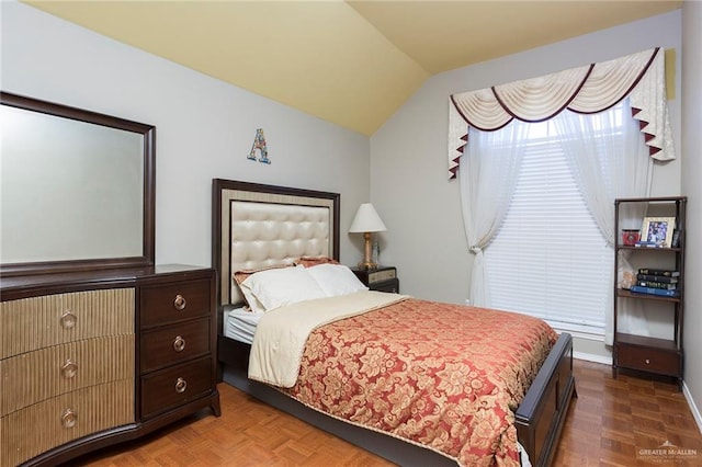 bedroom with dark parquet floors and lofted ceiling