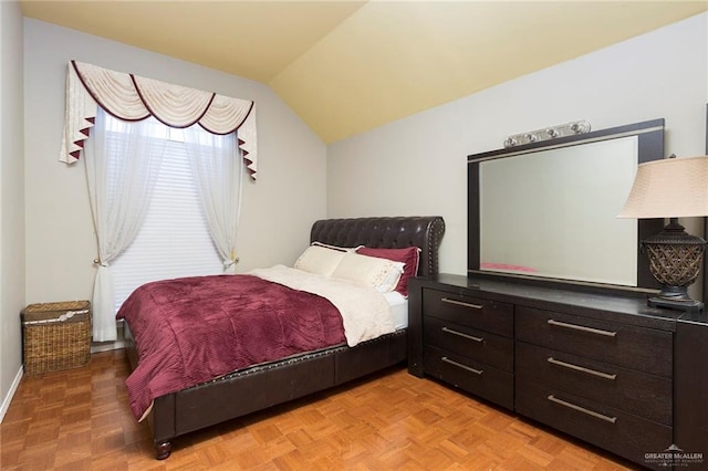 bedroom featuring lofted ceiling and parquet flooring