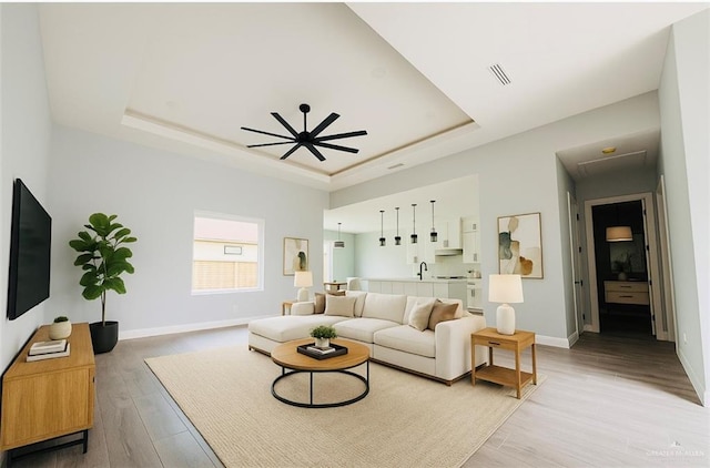 502 Pearl St, Edinburg, TX 78542 - living room with a raised ceiling, light wood-style floors, baseboards, and ceiling fan
