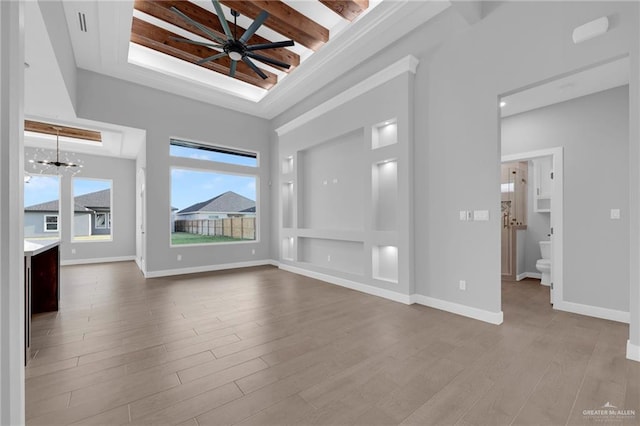 1101 Magnolia St, Mission, TX 78573 - unfurnished living room featuring wood finished floors, baseboards, stairway, a ceiling fan, and a tray ceiling