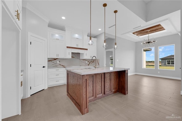 1101 Magnolia St, Mission, TX 78573 - kitchen featuring a sink, a chandelier, light wood-style flooring, glass insert cabinets, and light stone countertops