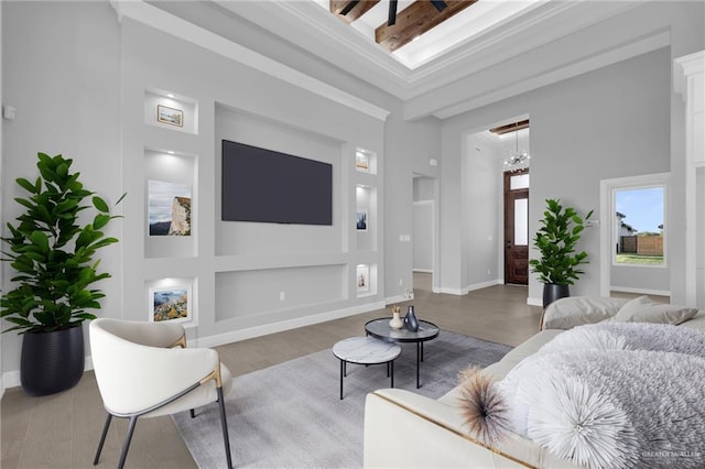 1101 Magnolia St, Mission, TX 78573 - living room with built in shelves, wood finished floors, a high ceiling, a chandelier, and baseboards