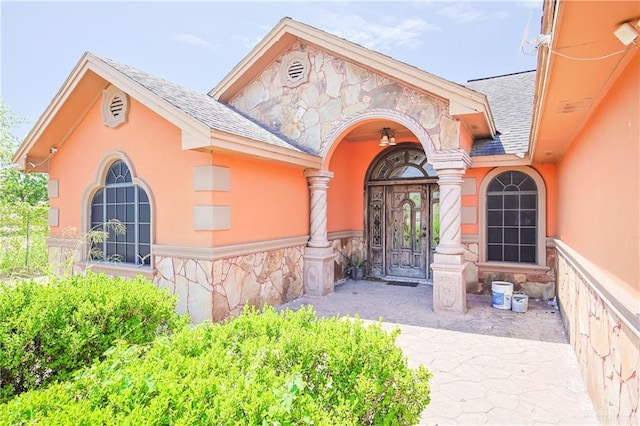 1722 Blue Bird Ave, Penitas, TX 78576 - property entrance with roof with shingles, stone siding, and stucco siding