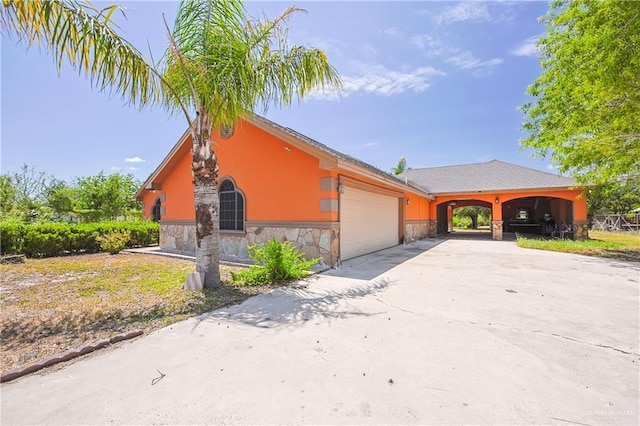 1722 Blue Bird Ave, Penitas, TX 78576 - view of front of home with an attached garage, stone siding, and driveway