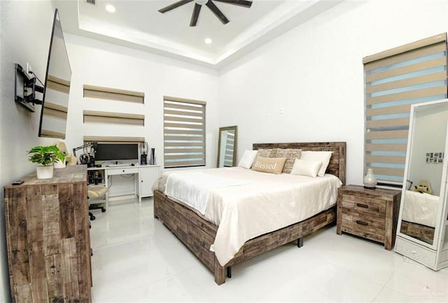 bedroom featuring ceiling fan, a raised ceiling, and light tile patterned floors