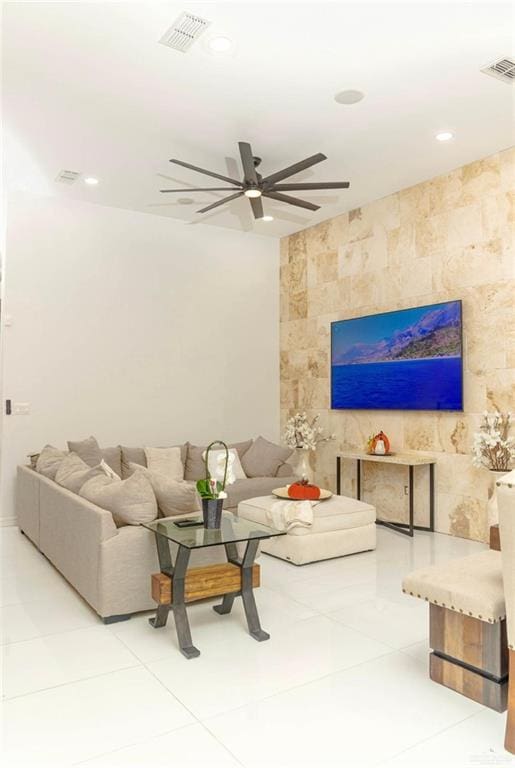 tiled living room featuring ceiling fan and tile walls