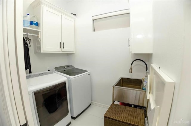 washroom with cabinets, sink, and washing machine and clothes dryer