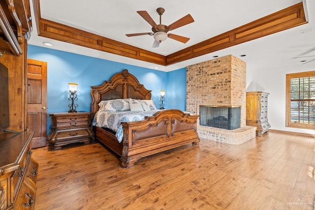 4301 Spring Creek Dr, Corpus Christi, TX 78410 - bedroom with wood finished floors, a fireplace, a raised ceiling, and ceiling fan