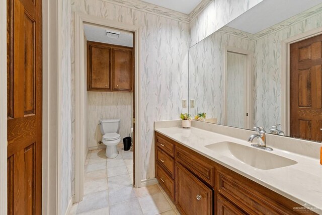 4301 Spring Creek Dr, Corpus Christi, TX 78410 - bathroom with wallpapered walls, vanity, tile patterned flooring, toilet, and baseboards