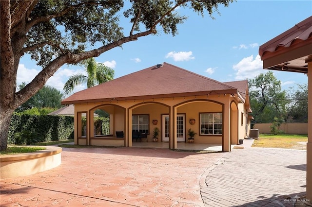 rear view of property with central air condition unit and a patio