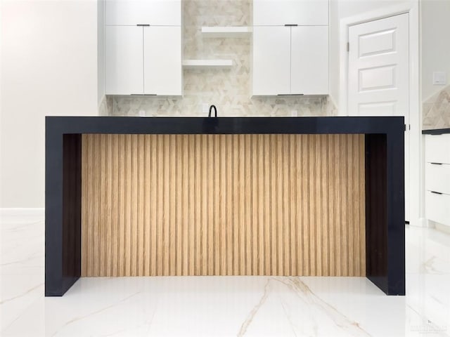 kitchen with dark countertops, marble finish floor, white cabinetry, and modern cabinets