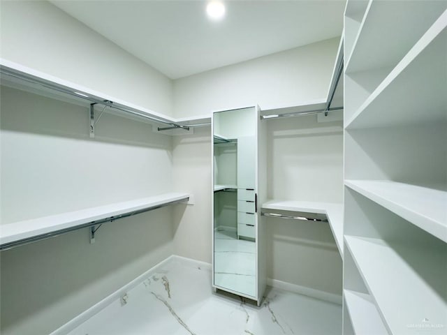 spacious closet featuring marble finish floor