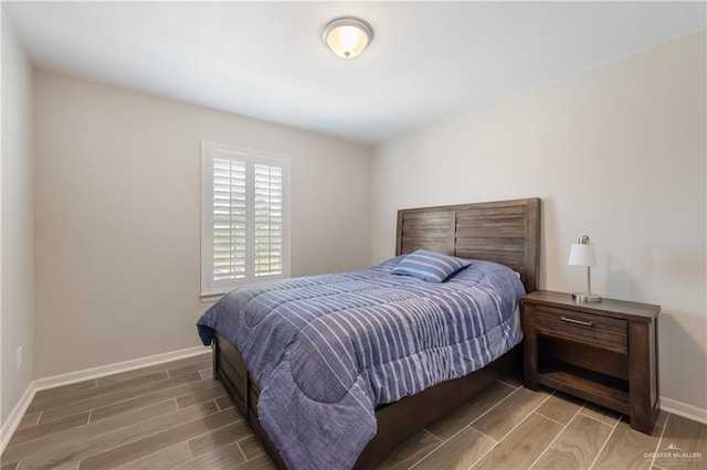 bedroom with baseboards and wood finish floors
