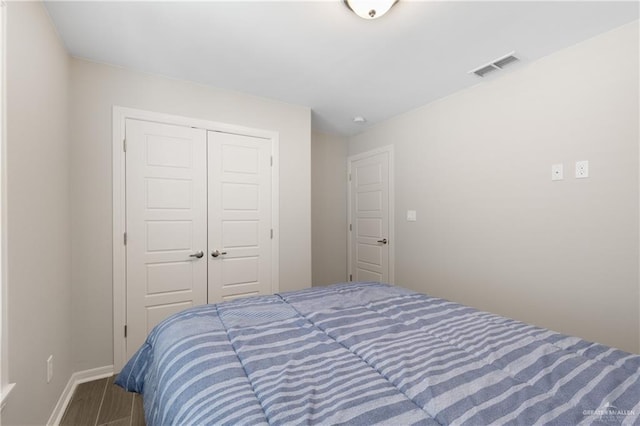 bedroom featuring baseboards, visible vents, and a closet