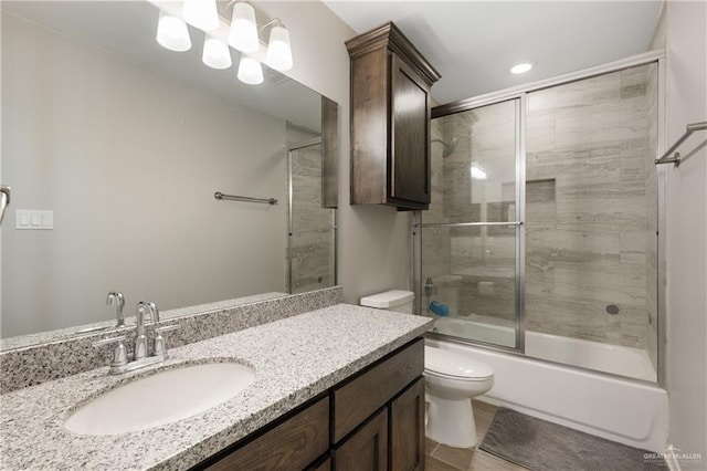 full bath featuring toilet, vanity, and bath / shower combo with glass door