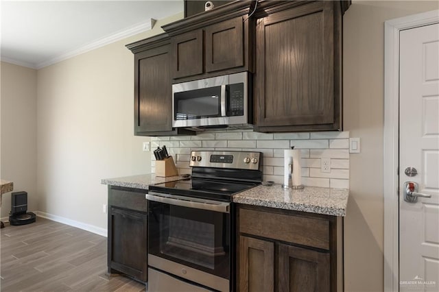 kitchen with dark brown cabinets, tasteful backsplash, ornamental molding, and stainless steel appliances
