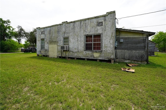 view of side of property featuring a lawn and cooling unit