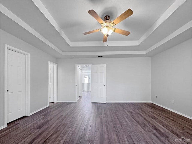 spare room featuring ceiling fan, dark hardwood / wood-style flooring, and a tray ceiling