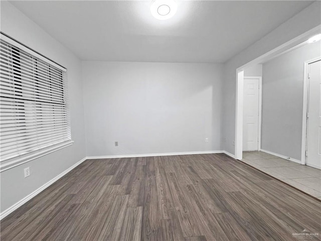 empty room with dark hardwood / wood-style flooring