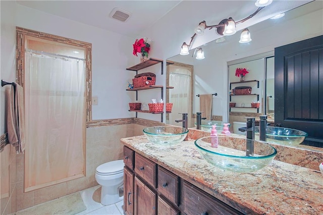 bathroom with tile walls, tile patterned flooring, vanity, curtained shower, and toilet