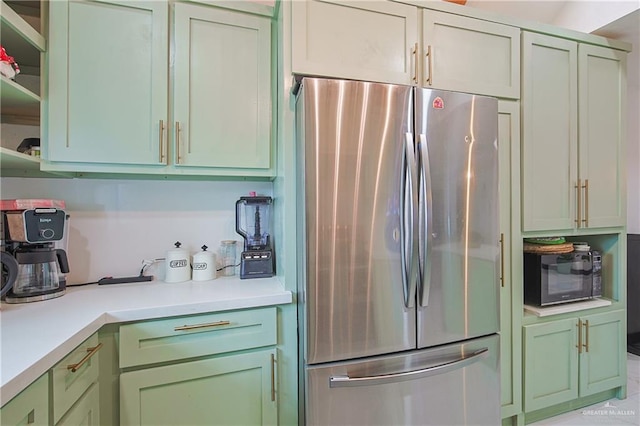 kitchen featuring green cabinetry and stainless steel fridge