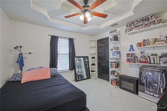 bedroom featuring a raised ceiling and ceiling fan