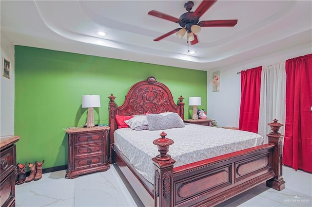 bedroom with a raised ceiling and ceiling fan