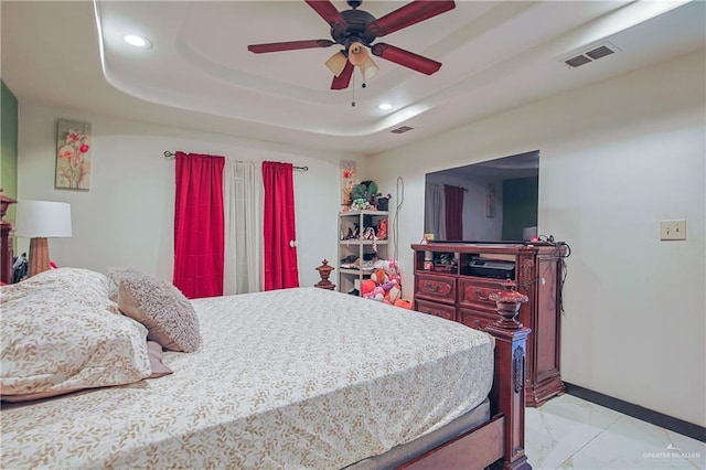 bedroom with ceiling fan and a raised ceiling