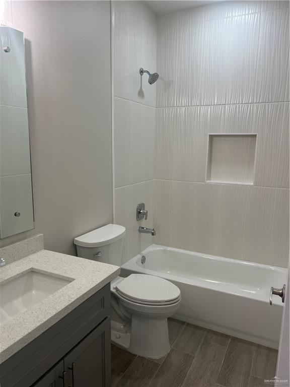 full bathroom featuring vanity, washtub / shower combination, and toilet