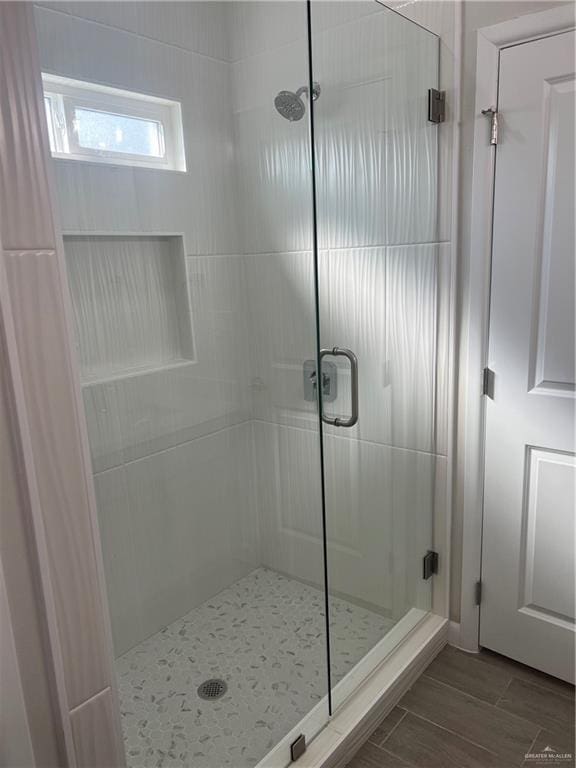 bathroom featuring a shower with shower door