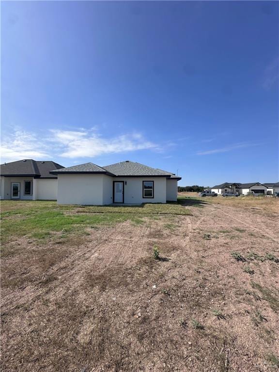 rear view of house featuring a yard