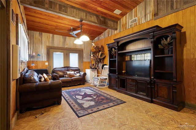 living room with vaulted ceiling with beams, ceiling fan, wooden ceiling, and wooden walls