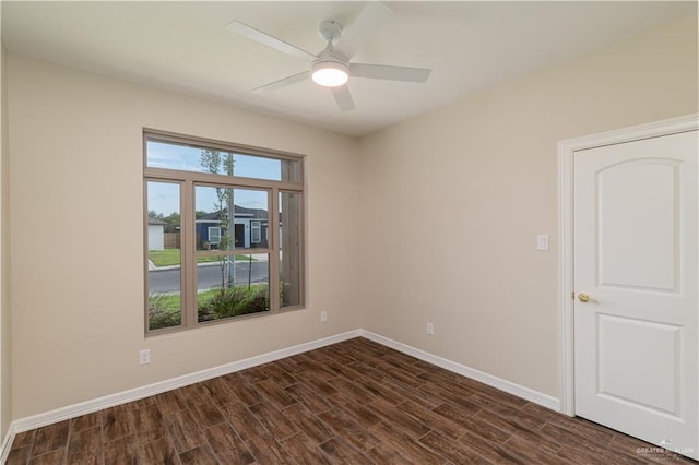 spare room with dark wood-type flooring and ceiling fan