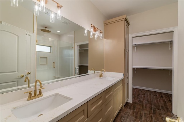 bathroom with wood-type flooring, vanity, and a shower with shower door