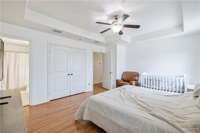 1041 Yellow Hammer St, Rio Grande City, TX 78582 - bedroom with a tray ceiling, wood finished floors, baseboards, ceiling fan, and connected bathroom