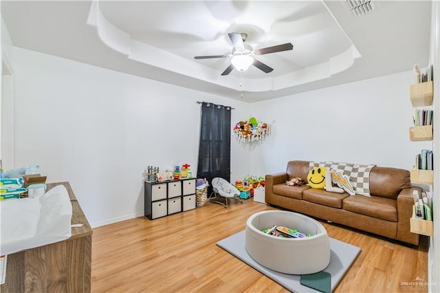 1041 Yellow Hammer St, Rio Grande City, TX 78582 - living area featuring a tray ceiling, wood finished floors, a ceiling fan, and baseboards