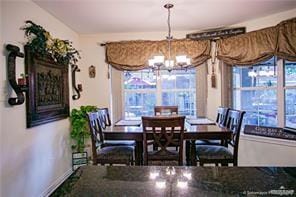 dining space with a healthy amount of sunlight and an inviting chandelier