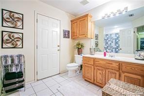 bathroom with tile patterned flooring, vanity, and toilet