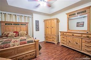 bedroom with dark hardwood / wood-style flooring and ceiling fan