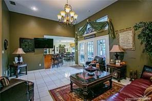 living room featuring tile patterned floors, french doors, and an inviting chandelier