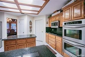 kitchen featuring light tile patterned floors, stainless steel appliances, and a notable chandelier