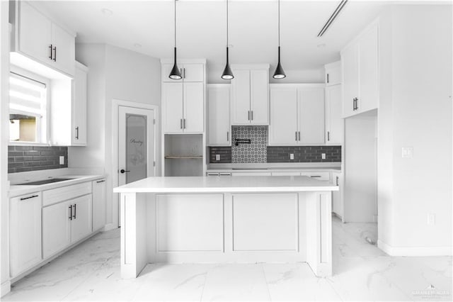 kitchen with hanging light fixtures, a center island, and white cabinets