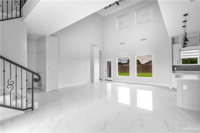 unfurnished living room featuring a high ceiling